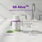 98 Alive immune support capsules with a glass of water on a bathroom counter.